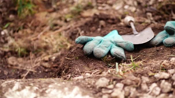 Toprak ortamda bahçıvan eldiveni ve kürek 4k seçici odak noktası - Video, Çekim