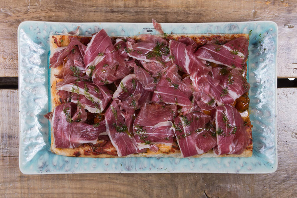 Italiaanse pizza met ham op een houten achtergrond - Foto, afbeelding