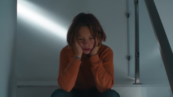 12-letni nastolatek siedzi smutno na schodach swojego domu, skąpany w słabym świetle, zagubiony we własnych myślach. Film omawia temat problemów nastolatków, samotności, niezrozumienia - Materiał filmowy, wideo