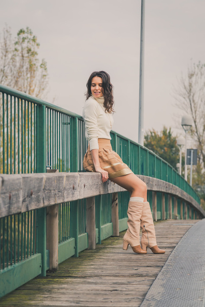 Beautiful young woman posing on a bridge - Foto, afbeelding