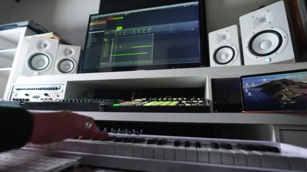 man die een elektrische piano speelt, project home studio muziek concept. Hoge kwaliteit 4k beeldmateriaal - Video