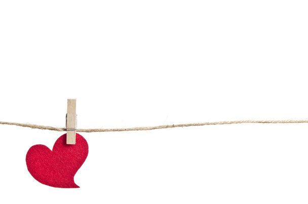 Red fabric heart hanging on the clothesline . On white backgroun - Φωτογραφία, εικόνα