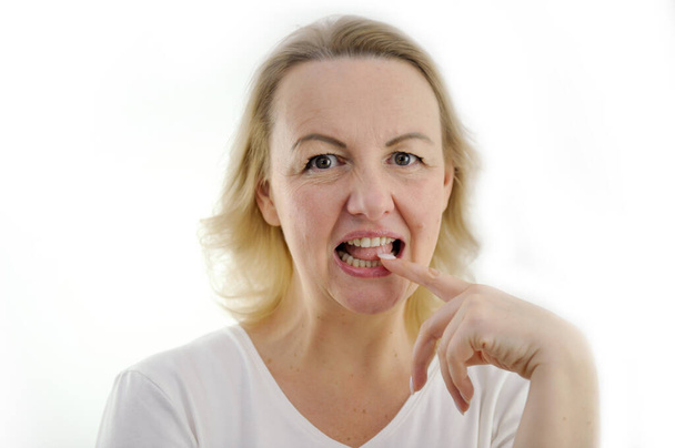 ajatella ehdotusta nainen vähän etusormi hampaat avattu silmät ja tarkastellaan kehykseen valkoinen tausta mielenkiintoinen tarjous, joka on vaikea kieltäytyä viihdyttävä tarina viestintä ajatella keskittyä - Valokuva, kuva