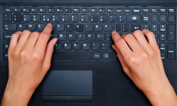 Hands typing text on a laptop keyboard - Fotoğraf, Görsel