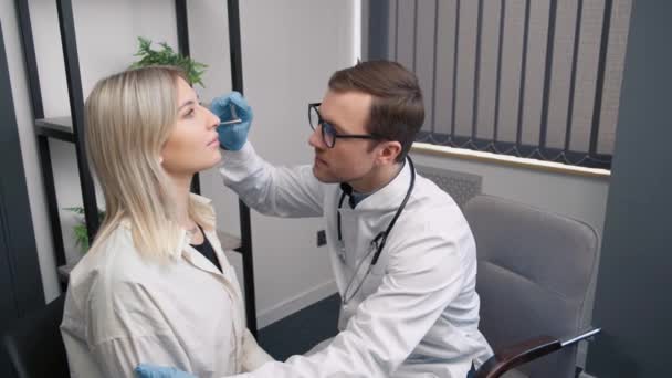 専門の男性医師otorhinolaryngologyは、現代の病院で聴診器で鼻検査を行います.鼻づまり,副鼻腔炎,アレルギーの概念 - 映像、動画