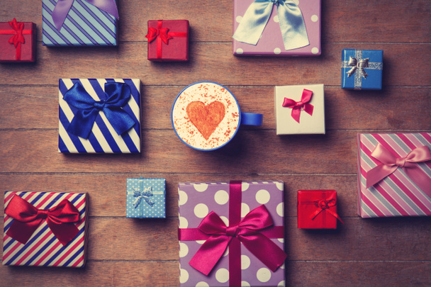 Cup and gift boxes on wooden background - Photo, Image