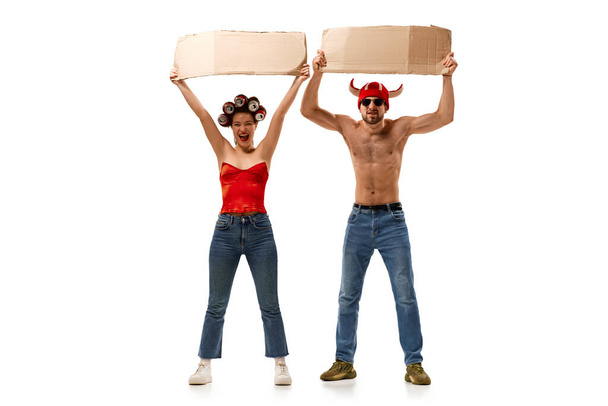 Full-length portrait of young man and woman holding cardboard posters with empty space for text over white background. Concept of human rights, freedom and equality, political issues - Fotografie, Obrázek