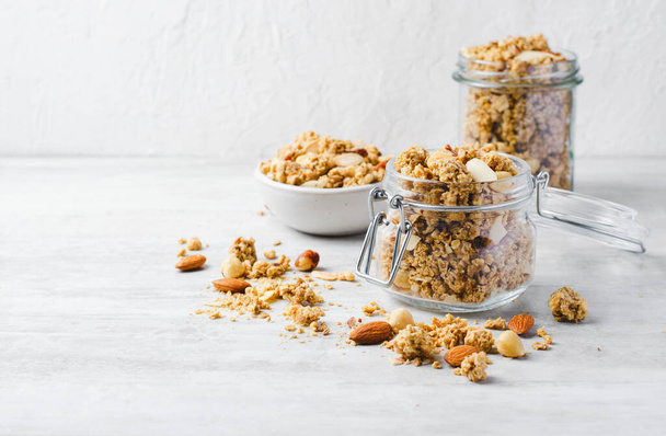 Granola with Nut Mix on Bright Concrete Background, Healthy Snack or Breakfast - Fotó, kép