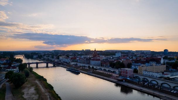 In Gorzw Wielkopolski, a drone photo was taken on a sunny day featuring the River Warta, the Cathedral, and the city center - Photo, Image