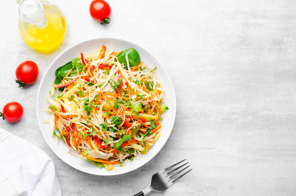 Frischer Gemüsesalat mit Kohl, Paprika und Karotten auf hellem Hintergrund, vegane, gesunde Ernährung - Foto, Bild