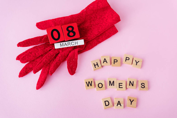 美しい赤いレースの手袋は、碑文3月8日、幸せな女性の日の碑文と木製のキューブ。休日のための準備ができてカード、女性の日 - 写真・画像