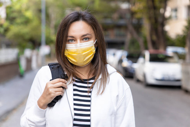 Portrait of young woman on street wearing face protective mask to prevent Coronaviru - Foto, afbeelding