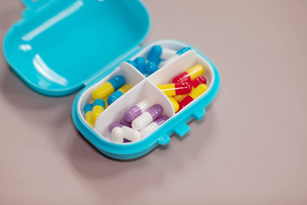 Plastic box with different pills on beige background. Space for text - Fotó, kép