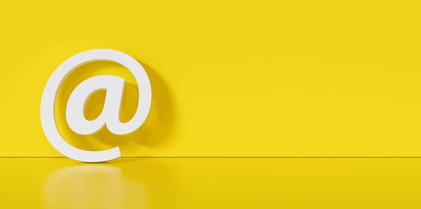 Icono de correo electrónico o en el signo apoyado en una pared amarilla como concepto de comunicación, espacio de copia para su texto individual.  - Foto, imagen