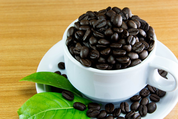 コーヒー豆とコーヒー木製テーブルの上の静物カップ - 写真・画像