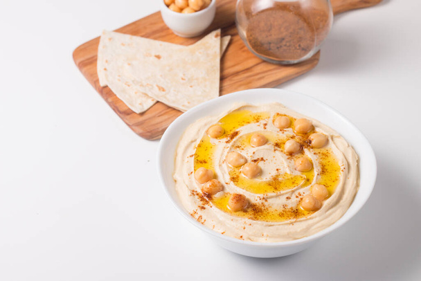 Hummus in a plate with chickpeas, smoked paprika, olive oil and  - Фото, изображение