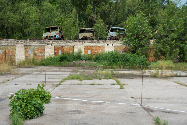 Dump van roestige oude voertuigen, Rossokha radioactieve voertuigen kerkhof in Tsjernobyl, Oekraïne - Julia 4 2021. Hoge kwaliteit foto - Foto, afbeelding