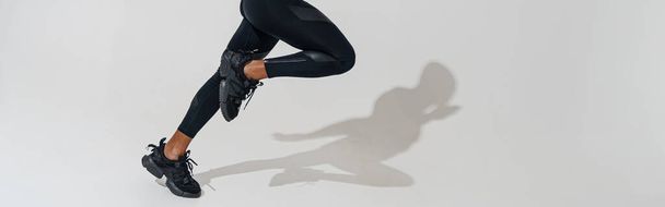 Professional male athlete running and looks ahead isolated on white studio background with shadows - Фото, изображение