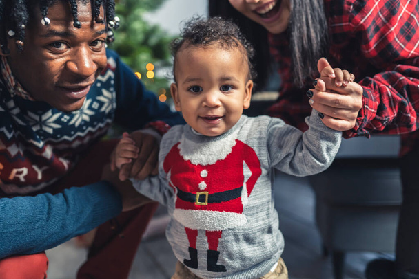 keskipitkällä laukaus super söpö pieni poika vanhempiensa kanssa jouluaattona, juhlava tunnelma. Laadukas kuva - Valokuva, kuva