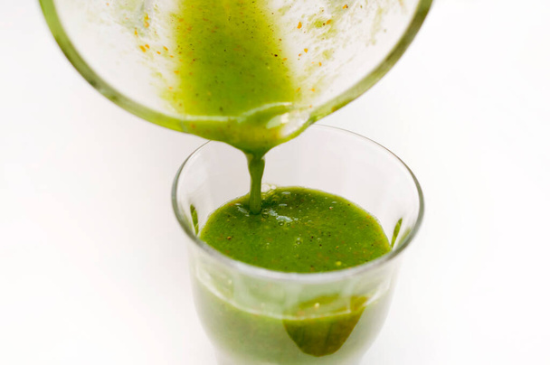 Verser le smoothie vert sain dans le verre.Smoothie vert à base de légumes à feuilles vertes et de fruits - Photo, image