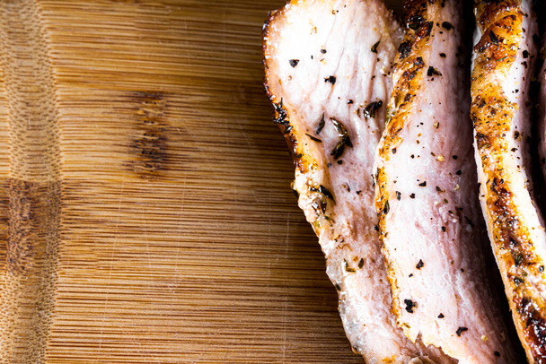 Pork steak roasted on a wooden board and sliced. Copy space. - Foto, Imagen
