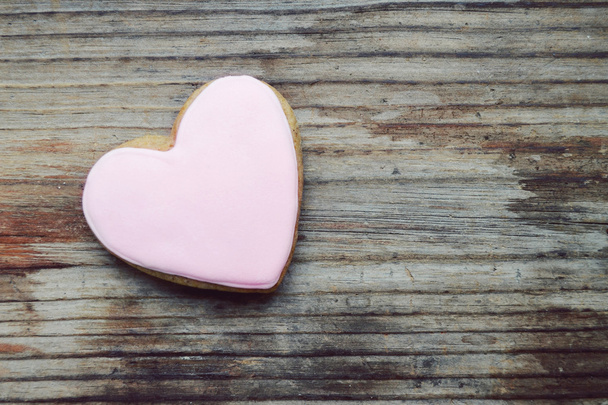 Ahşap masa üzerine pembe krema ile kalp şeklinde gingerbread - Fotoğraf, Görsel