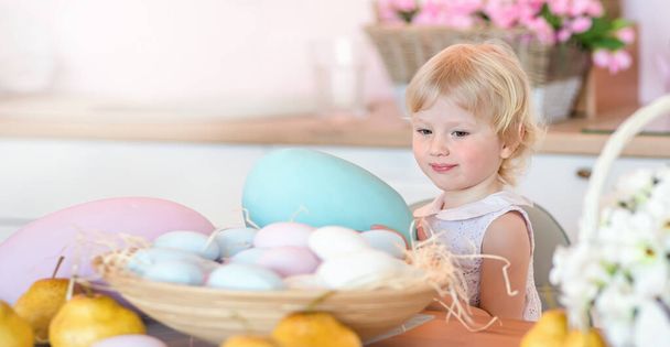 Маленька дитина тримає в руках велике кольорове пасхальне яйце. Пасхальна листівка з місцем для копіювання
 - Фото, зображення