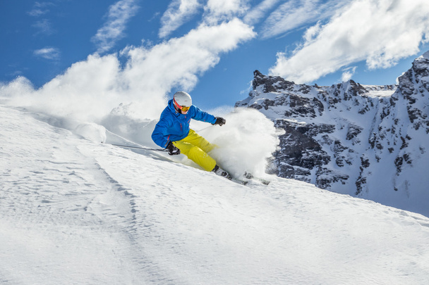 Skier skiing downhill in high mountains - Fotó, kép