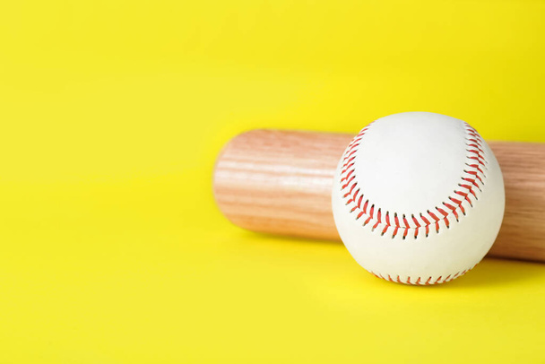 Wooden baseball bat and ball on yellow background, closeup. Space for text - Foto, Imagem