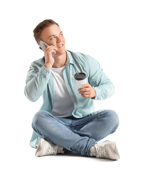 Jeune homme parlant par smartphone sur fond blanc - Photo, image