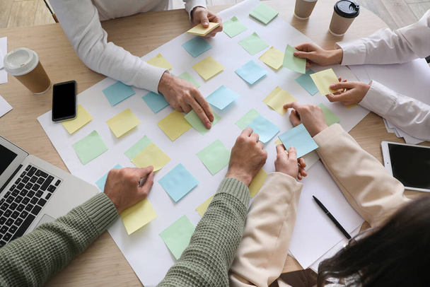 Grupo de personas con notas adhesivas que trabajan en el plan de negocios en la mesa en la oficina, primer plano - Foto, Imagen