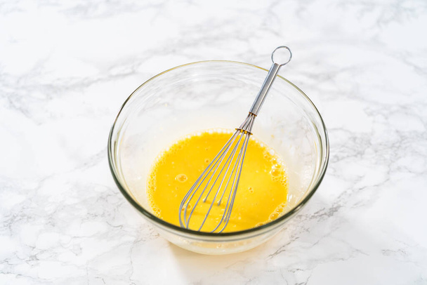 Zitronenkeilplätzchen mit Zitronenglasur. Nasse Zutaten in einer großen Glasschüssel mischen, um Zitronenplätzchen zu backen. - Foto, Bild