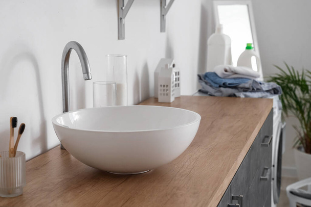 Fehér mosogató a pulton a világos fürdőszobában - Fotó, kép