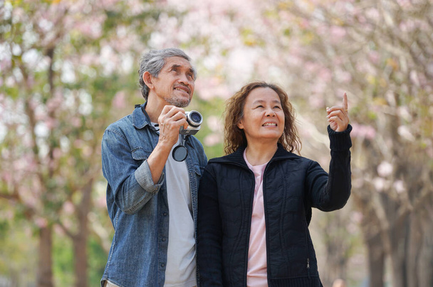 portré romantikus ázsiai idős pár turista séta, beszél a természetben, és látta a virágok tavasszal, koncepció az idős életmód, pihentető, utazás, jólét, idős egészségügyi ellátások a természetben - Fotó, kép