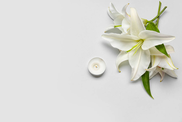 Beautiful lily flowers and candle on white background - Foto, Imagen