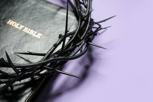 Corona di spine e Sacra Bibbia su sfondo lilla, primo piano - Foto, immagini