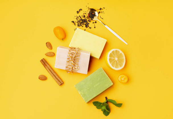 Composition with soap bars and natural ingredients on yellow background - Foto, imagen