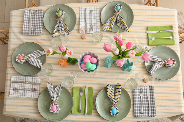 Tulpenblumen, Hasen und bemalte Eier auf festlichem Tisch zum Osterfest serviert - Foto, Bild