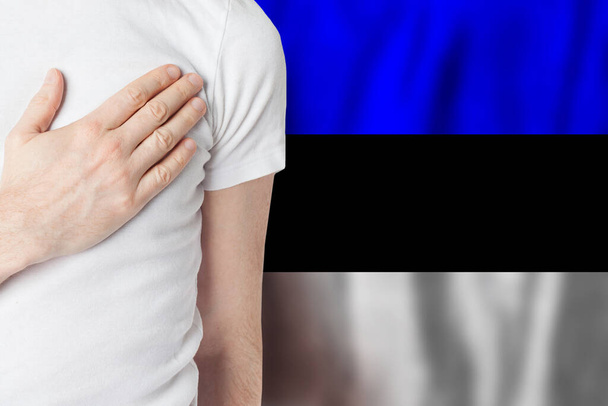 Estonian person with hand on heart on the background of Estonia flag. Patriotism, country, national, pride concept - Foto, immagini