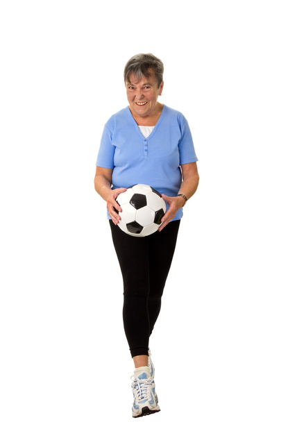 Senior vrouw lopen met voetbal - Foto, afbeelding