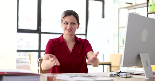 A tanácsadó irodában dolgozó női menedzser gesztussal hív. Seo hívogató üdvözlet boldog és mosolygós - Felvétel, videó