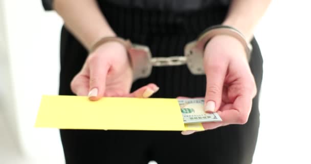 Frau in Handschellen hält Bestechungsgeld in Umschlag. Verwaltungs- und strafrechtliche Haftung für Finanzverbrechen - Filmmaterial, Video