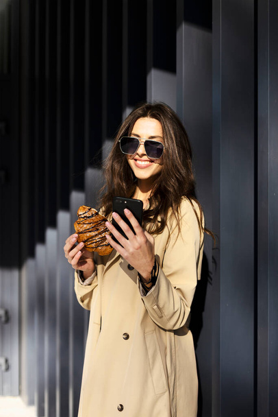 Smiling, cute woman in sunglasses outdoors. Young woman on a gray background. - Φωτογραφία, εικόνα