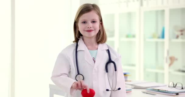 Πορτρέτο του όμορφου κοριτσιού γιατρός κρατώντας την καρδιά. Καρδιαγγειακές παθήσεις σε παιδιά και θεραπεία - Πλάνα, βίντεο