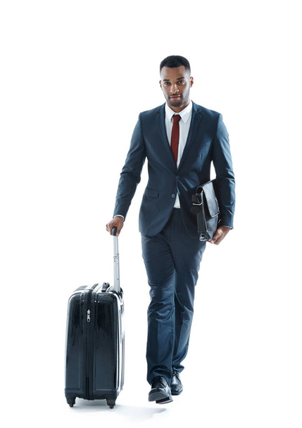 İşe gidiyormuş. Yakışıklı, genç, Afro-Amerikan bir işadamı beyaz bavulunun yanında tek başına yürürken... - Fotoğraf, Görsel