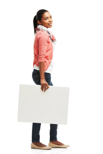 Carrying some copyspace. Casual young woman holding white copyspace against a white background - Photo, Image
