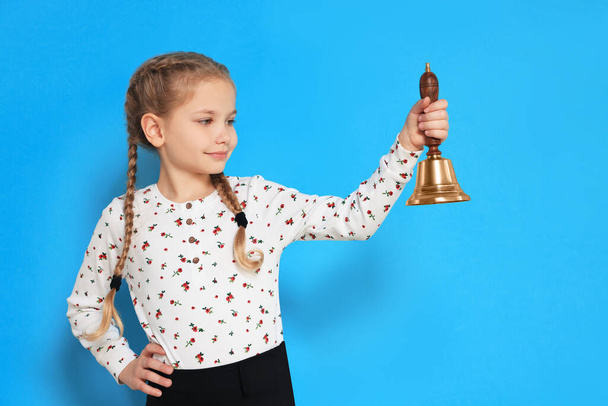 Pupil with school bell on light blue background - Photo, Image