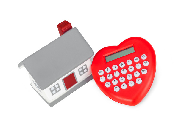 Rekenmachine hartvormige en miniatuur huis. - Foto, afbeelding