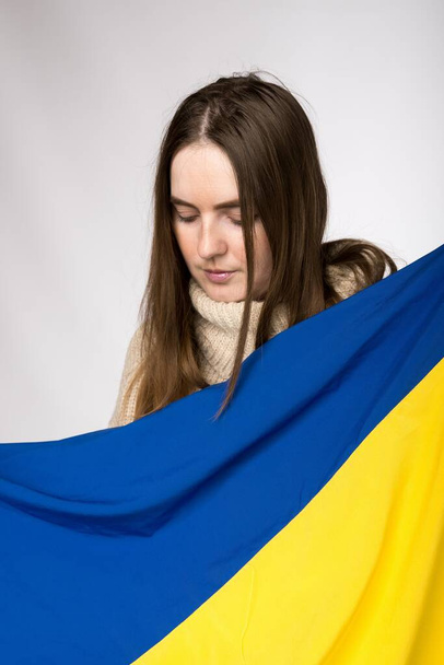 Euroopan näköinen tyttö pitää käsissään Ukrainan lippua - Valokuva, kuva