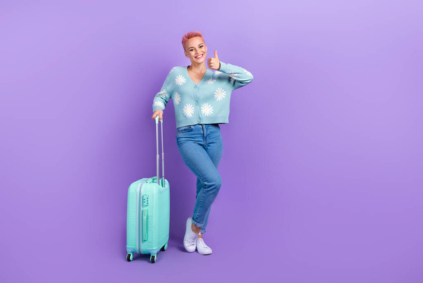 Full body photo of satisfied girl flower print cardigan like recommend flying company fast destination luggage isolated on violet color background. - Photo, Image